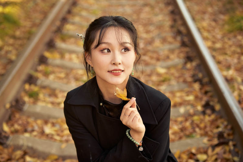 深秋午后在废弃铁轨上拍照的亚洲美女