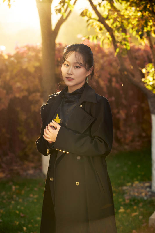 阳光明媚的午后在公园树林拍照的美女