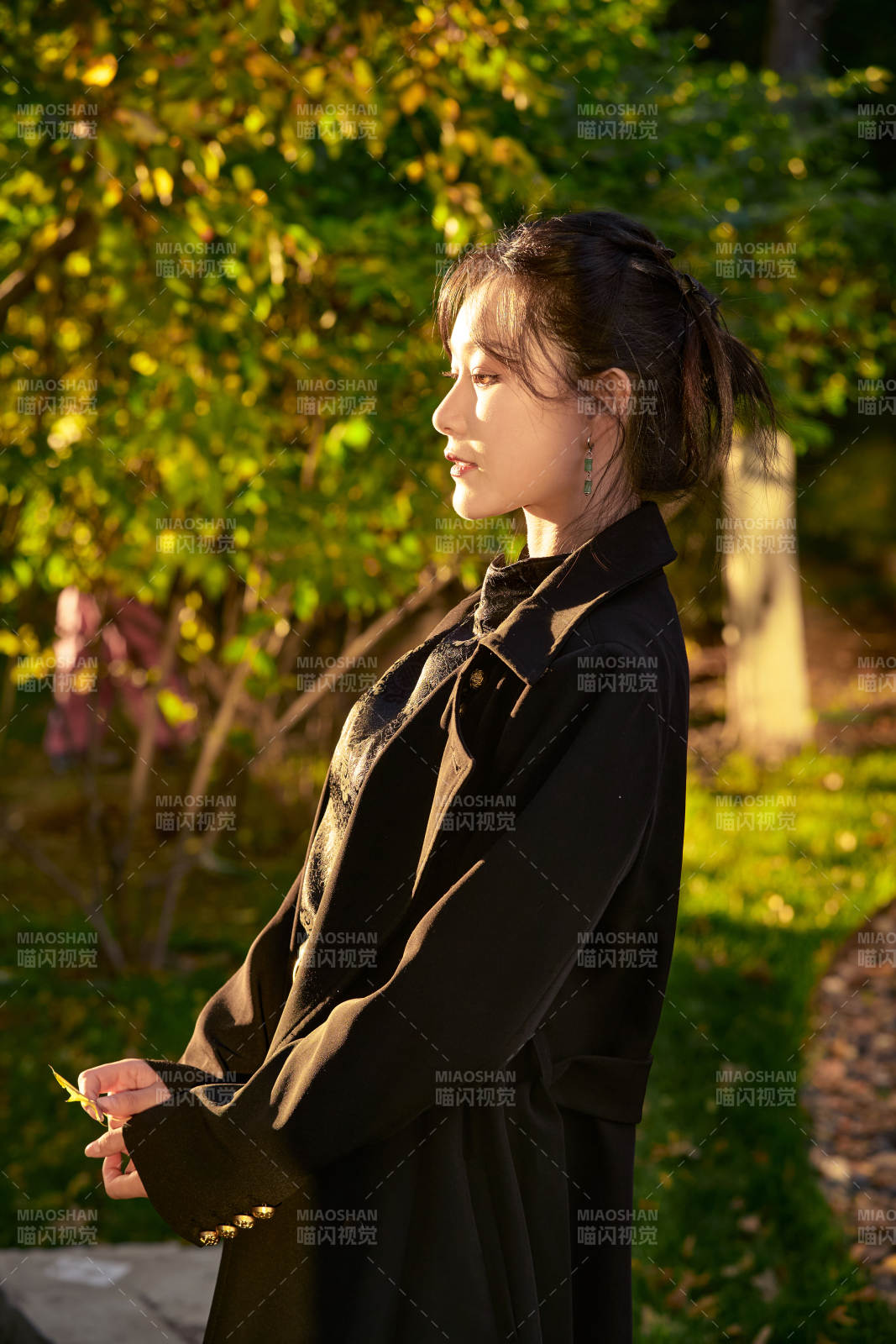 阳光明媚的午后在公园树林拍照的美女