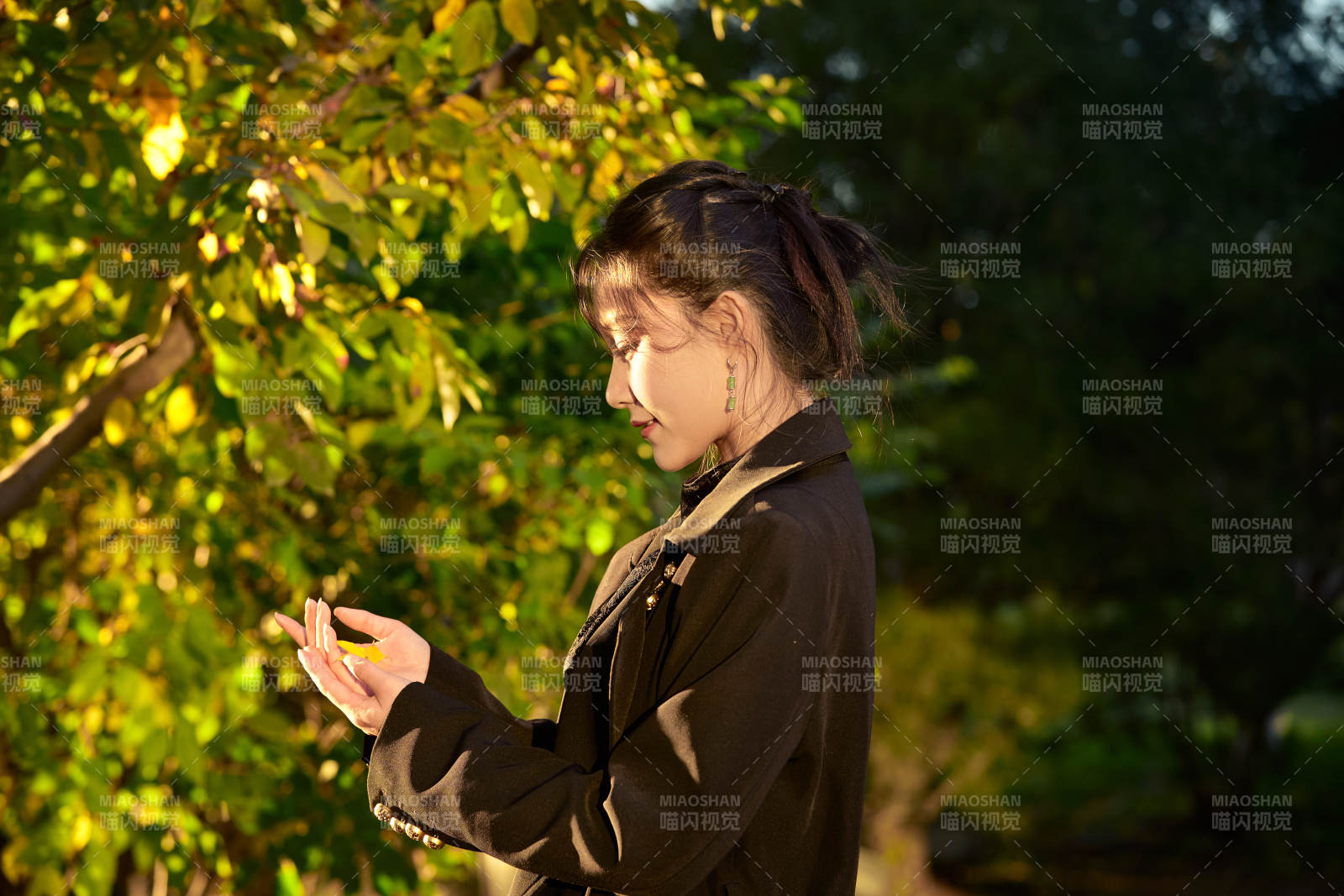 阳光明媚的午后在公园树林拍照的美女