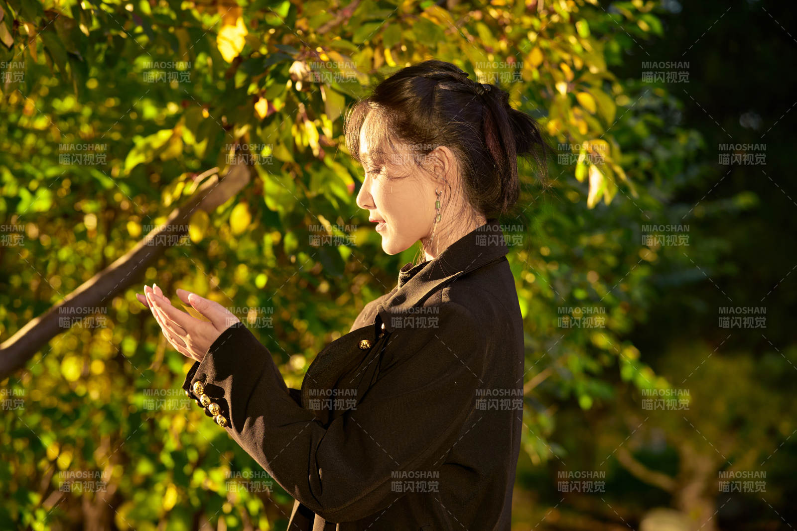 阳光明媚的午后在公园树林拍照的美女