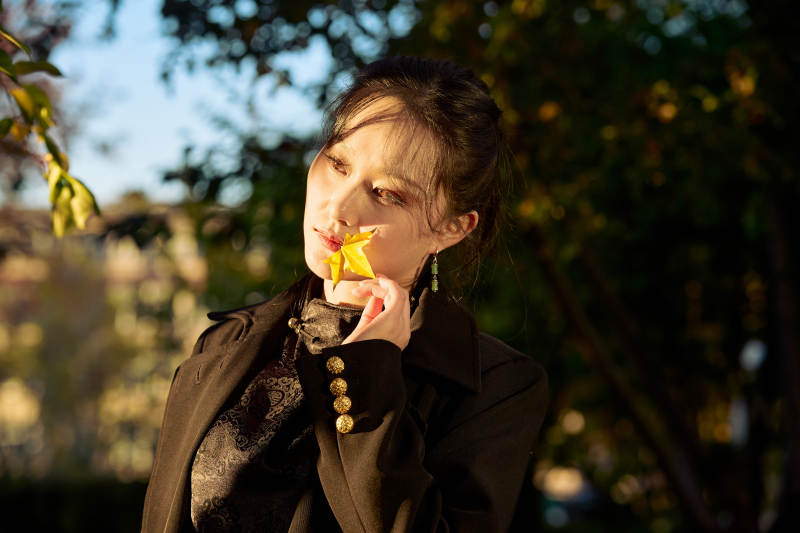 阳光明媚的午后在公园树林拍照的美女