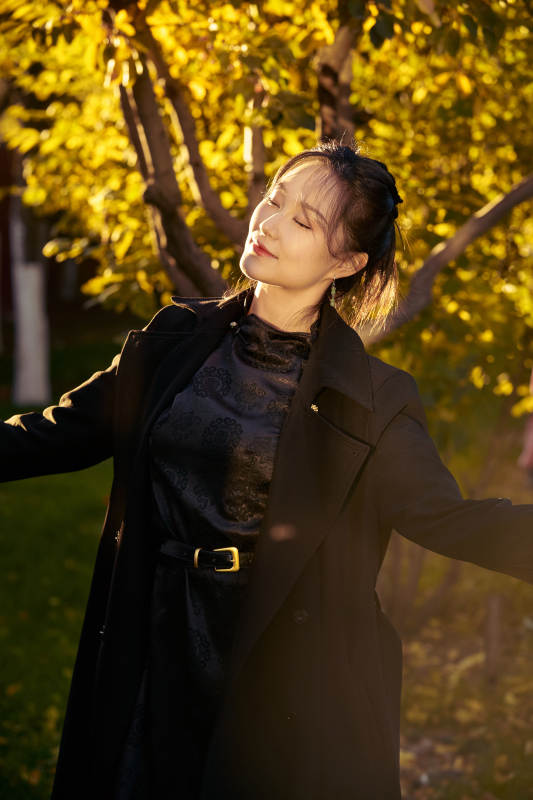 阳光明媚的午后在公园树林拍照的美女