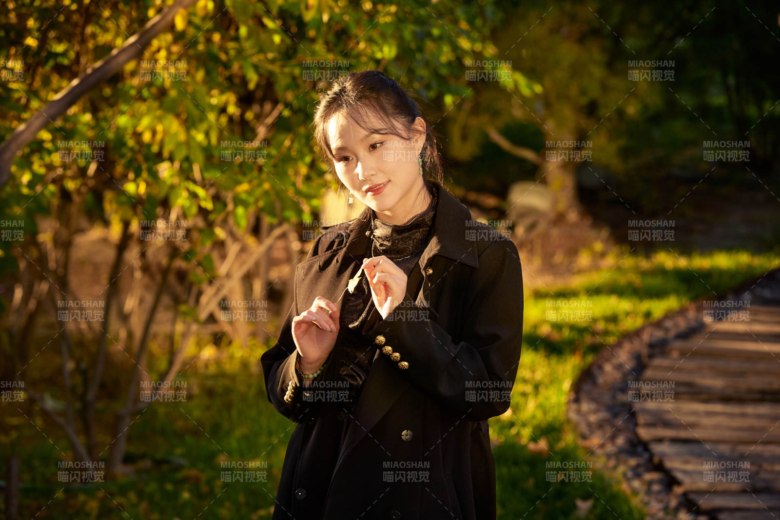 阳光明媚的午后在公园树林拍照的美女