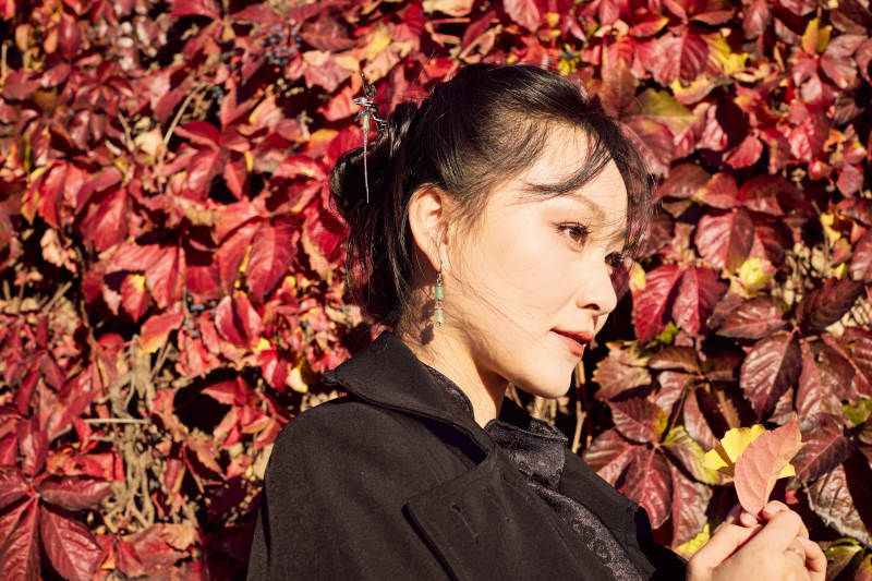 秋天在红叶遍布的河边拍照的亚洲女性