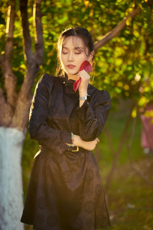 阳光明媚的午后在公园树林拍照的美女