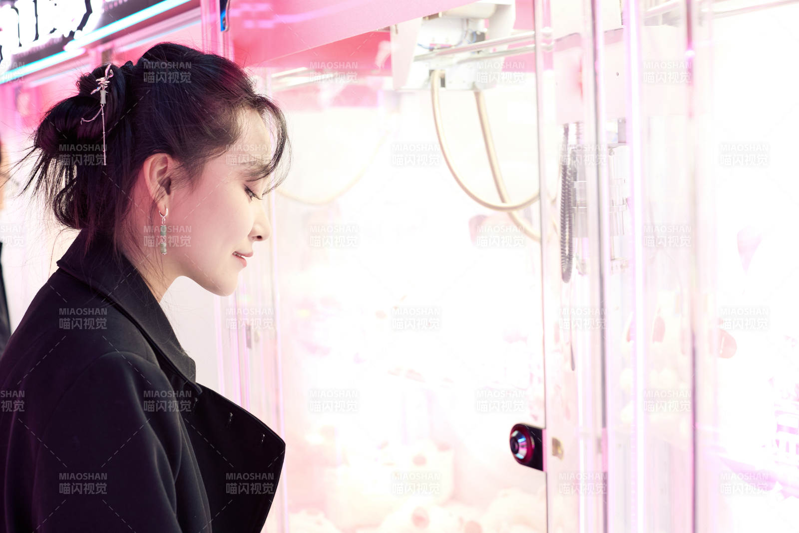 在娱乐城玩抓娃娃机的美女