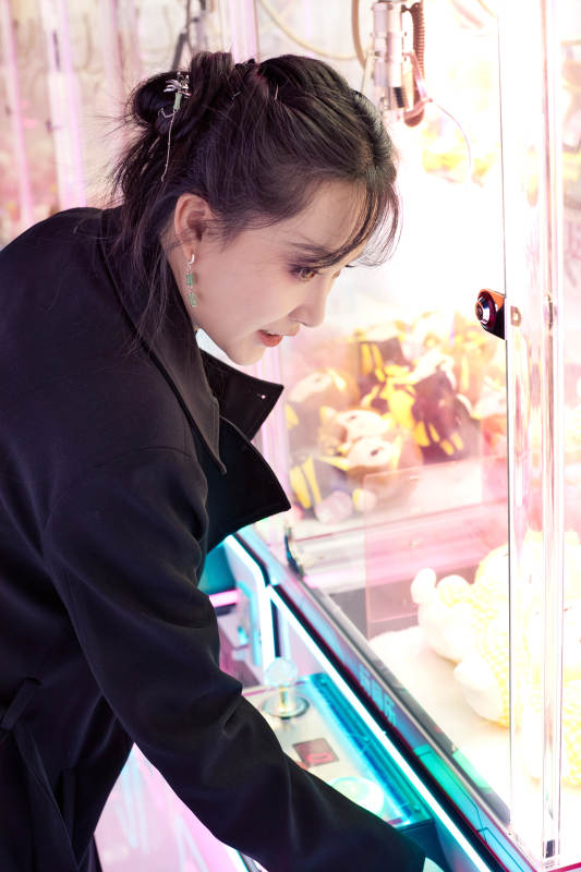 在娱乐城玩抓娃娃机的美女