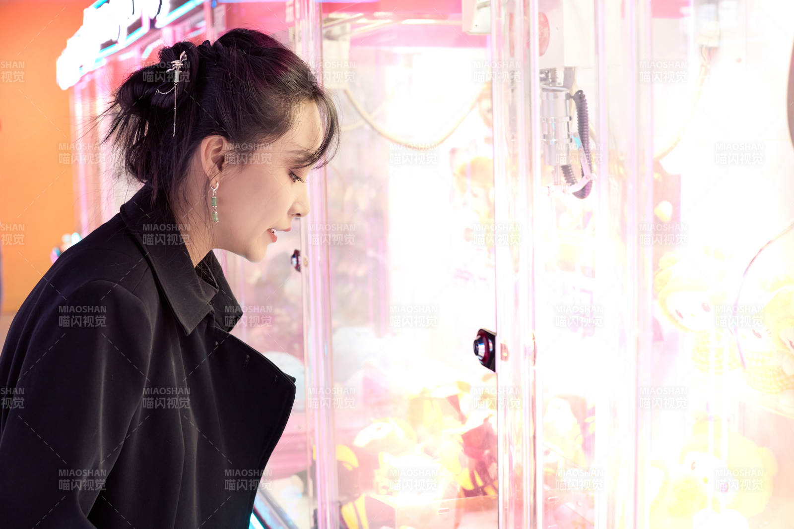 在娱乐城玩抓娃娃机的美女