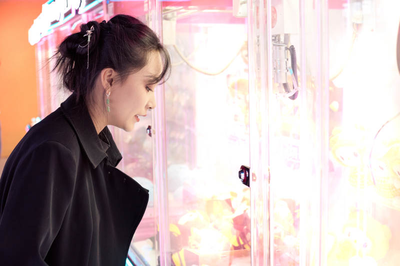 在娱乐城玩抓娃娃机的美女