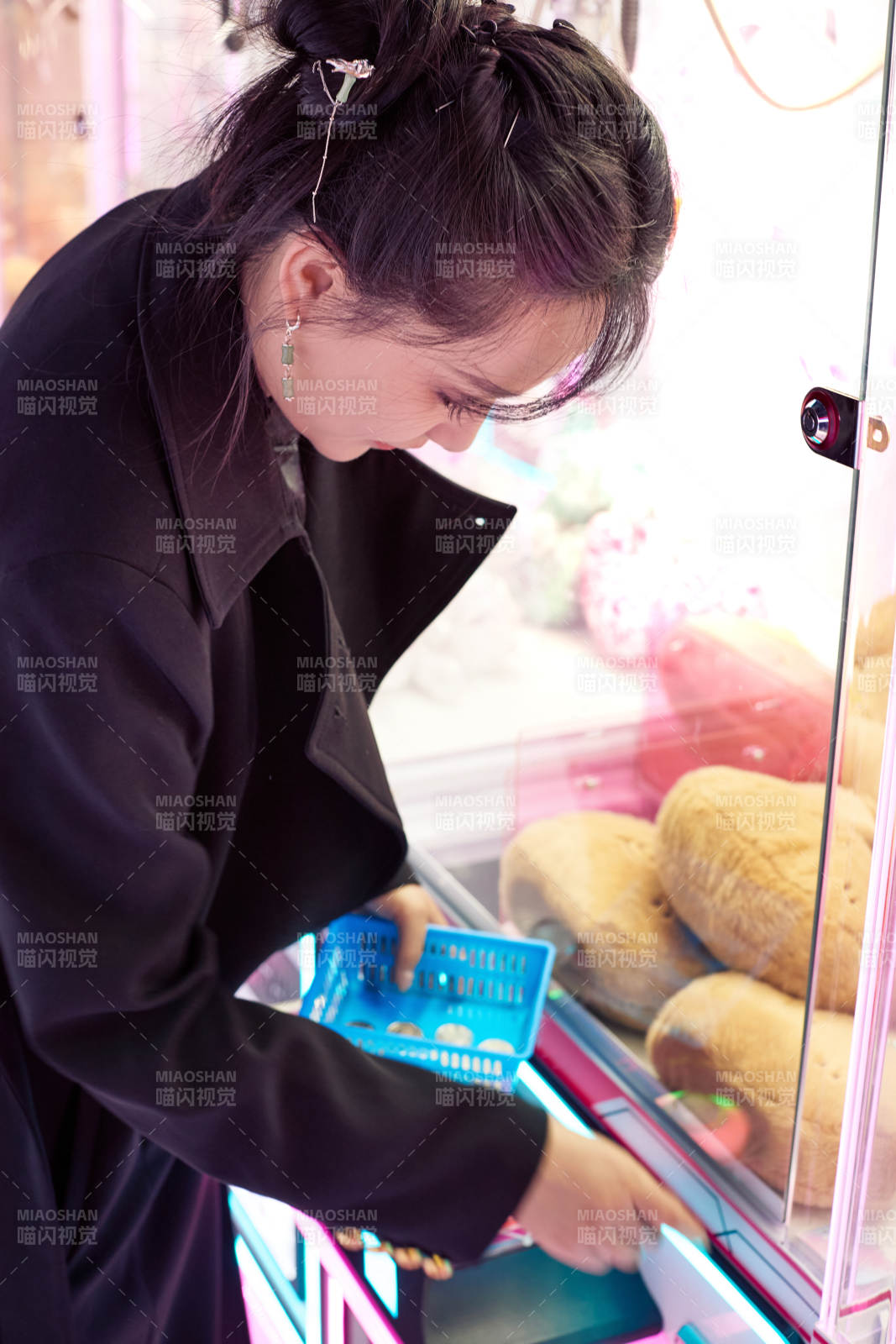 在娱乐城玩抓娃娃机的美女