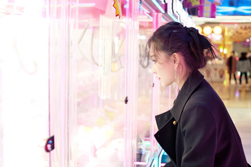 在娱乐城玩抓娃娃机的美女