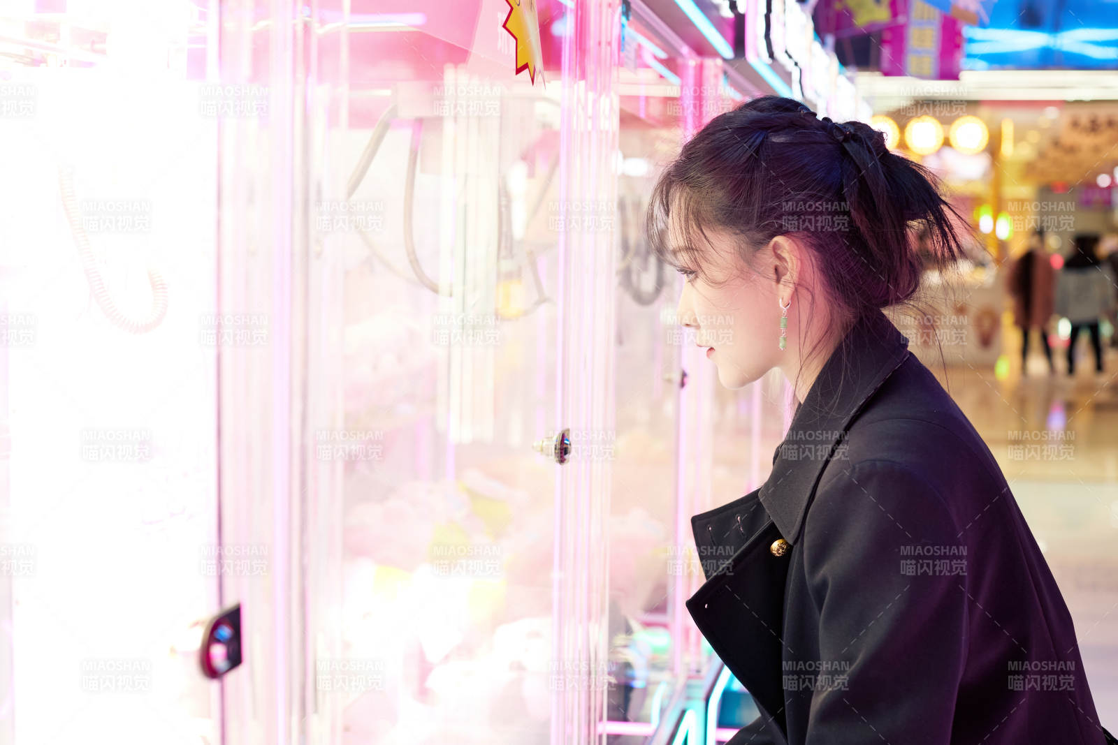 在娱乐城玩抓娃娃机的美女