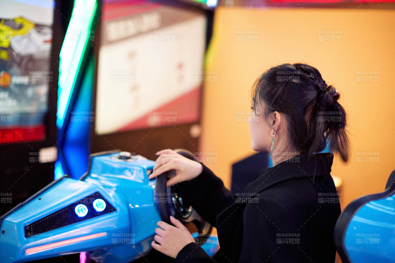 周末在电子游戏娱乐玩赛车游戏的美女
