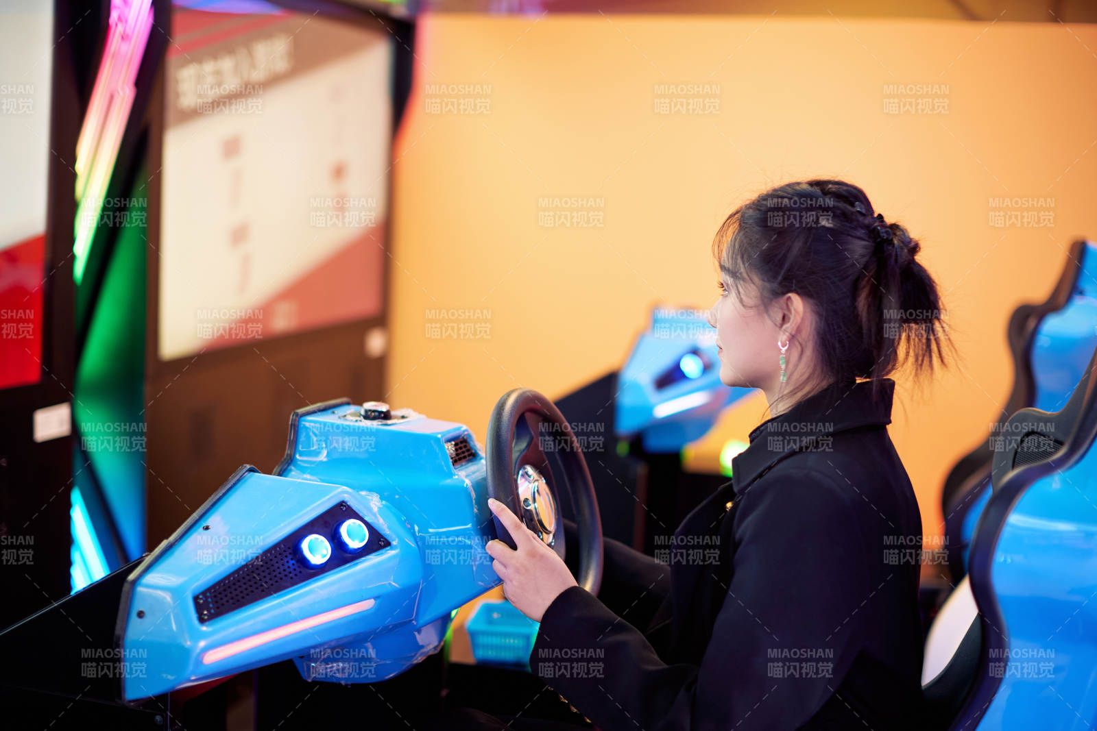 周末在电子游戏娱乐玩赛车游戏的美女