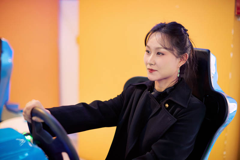 周末在电子游戏娱乐玩赛车游戏的美女