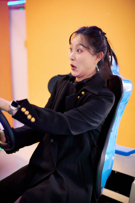 周末在电子游戏娱乐玩赛车游戏的美女