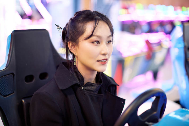 周末在电子游戏娱乐玩赛车游戏的美女