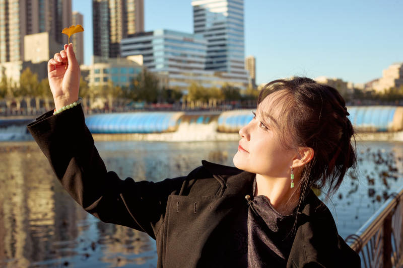 秋天在红叶遍布的河边拍照的亚洲女性