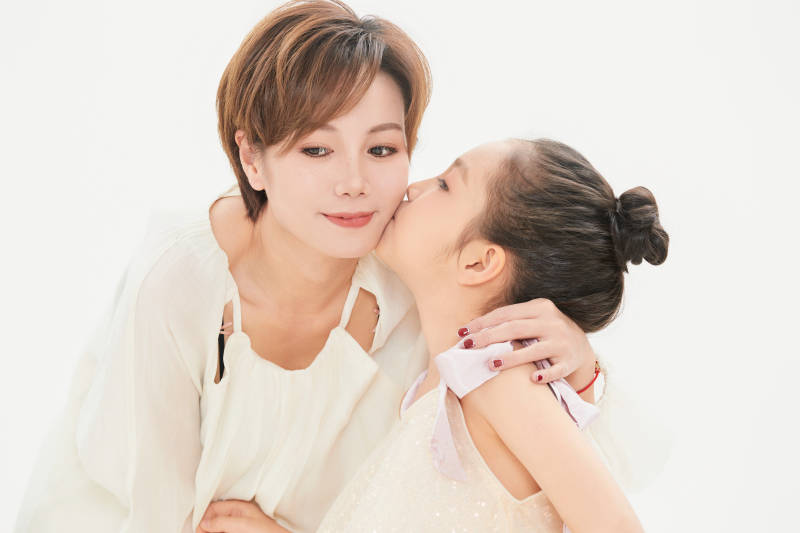 白色背景里的美丽妈妈与可爱女儿亲子人像