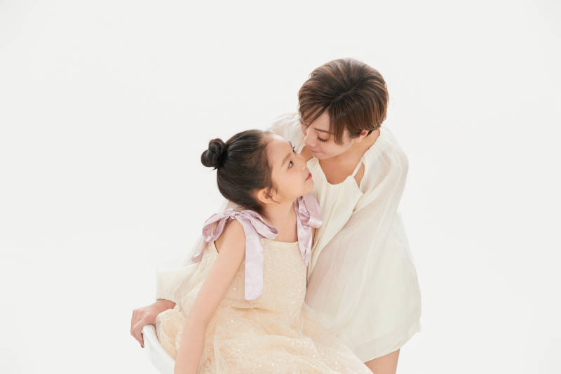白色背景里的美丽妈妈与可爱女儿亲子人像