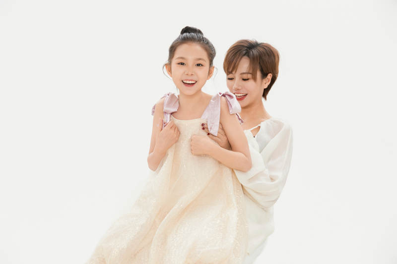白色背景里的美丽妈妈与可爱女儿亲子人像