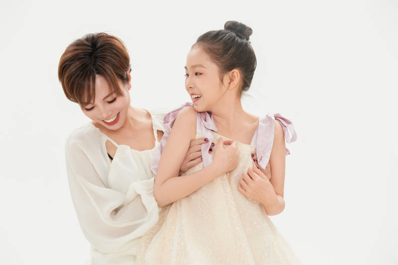 白色背景里的美丽妈妈与可爱女儿亲子人像