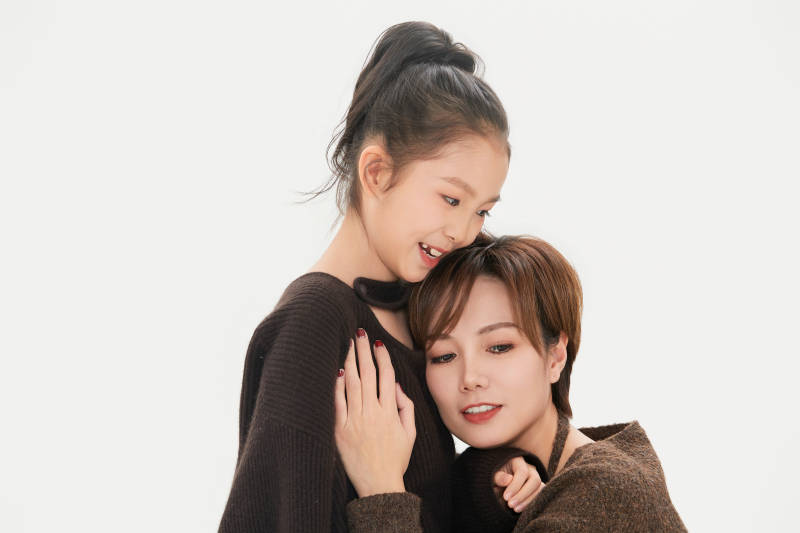 白色背景里的美丽妈妈与可爱女儿亲子人像