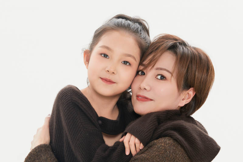 白色背景里的美丽妈妈与可爱女儿亲子人像