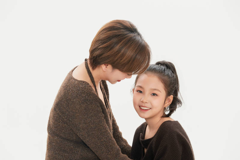 白色背景里的美丽妈妈与可爱女儿亲子人像