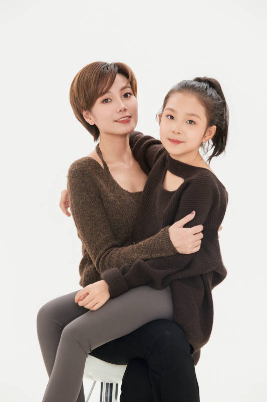 白色背景里的美丽妈妈与可爱女儿亲子人像