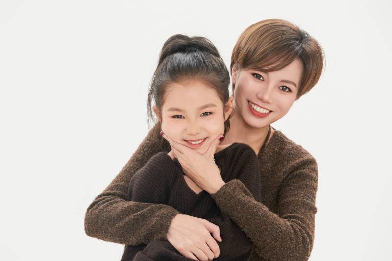 白色背景里的美丽妈妈与可爱女儿亲子人像