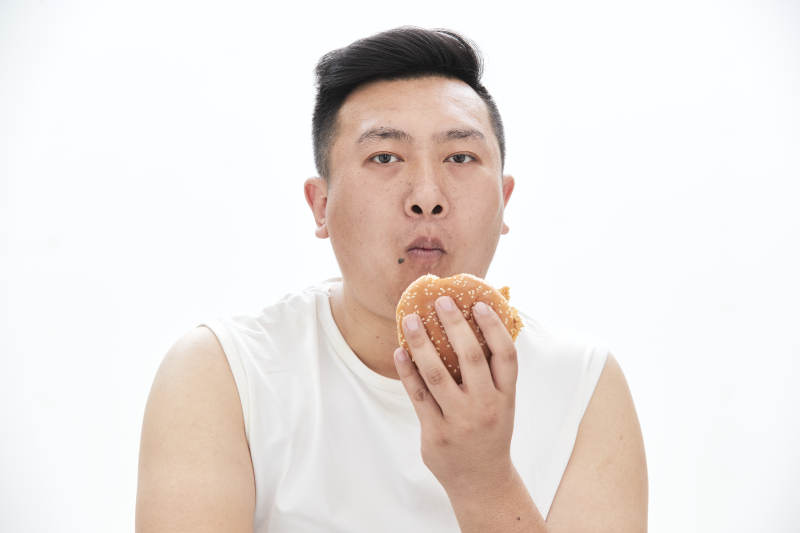 大吃特吃各种食物的肥胖亚洲男子