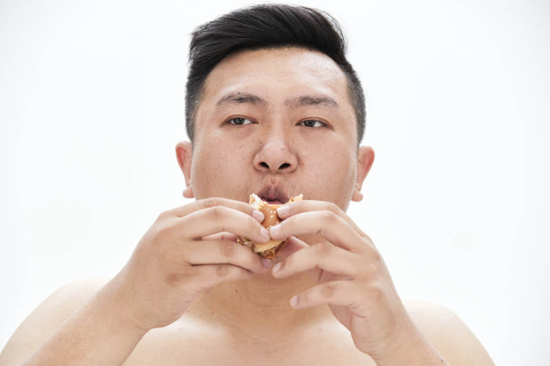 大吃特吃各种食物的肥胖亚洲男子