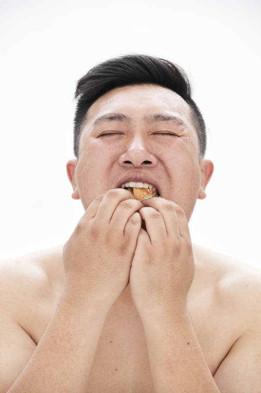 大吃特吃各種食物的肥胖亞洲男子