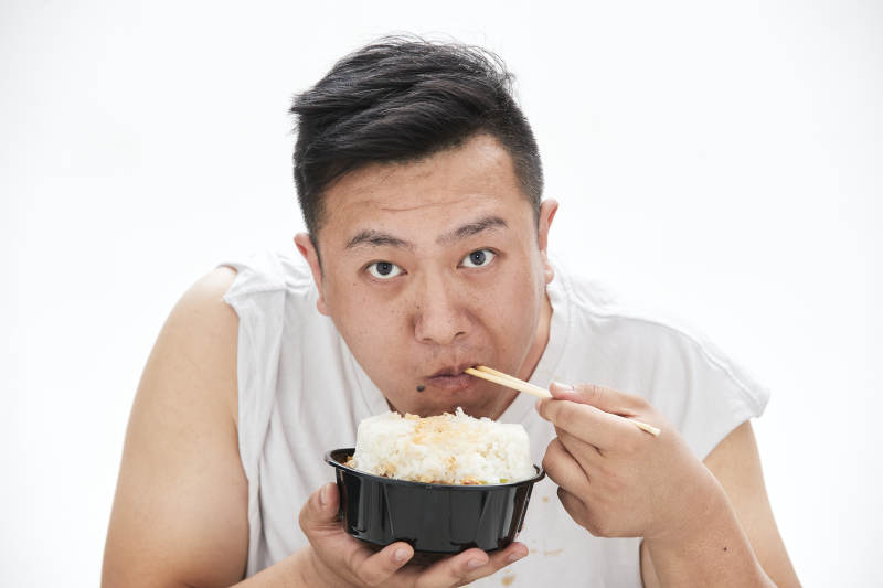 大吃特吃各种食物的肥胖亚洲男子