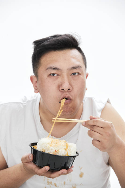 大吃特吃各种食物的肥胖亚洲男子