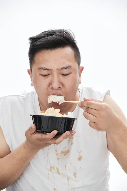 大吃特吃各种食物的肥胖亚洲男子