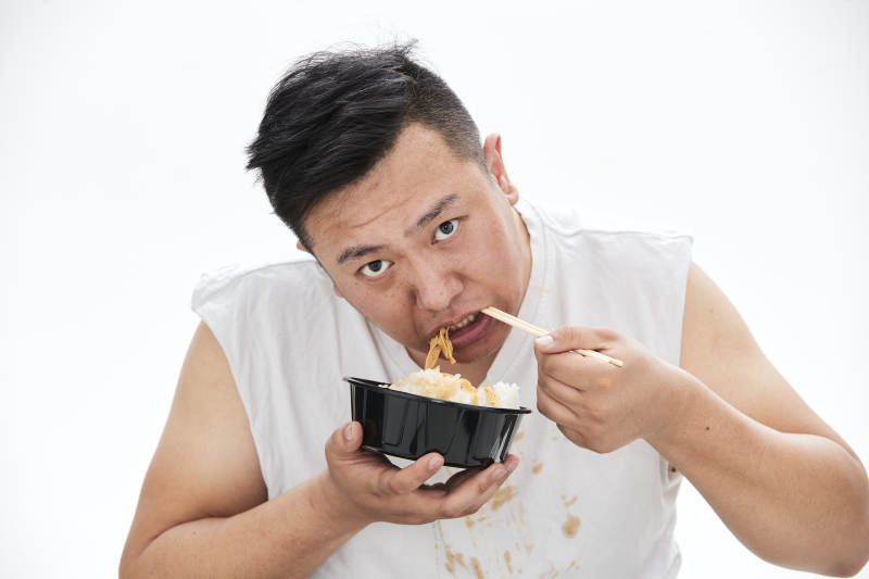 大吃特吃各种食物的肥胖亚洲男子