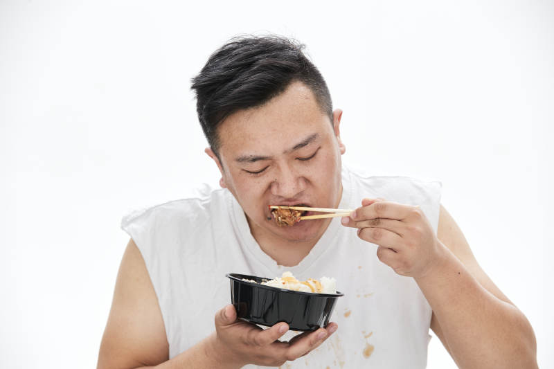大吃特吃各种食物的肥胖亚洲男子