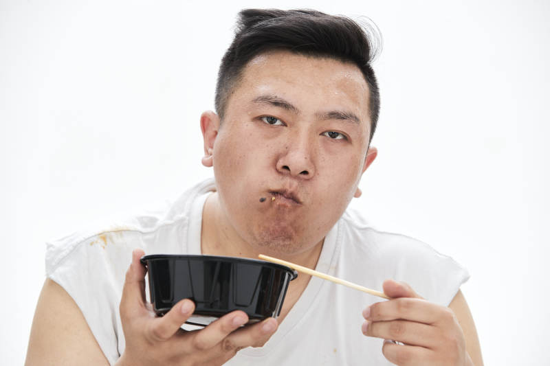 大吃特吃各种食物的肥胖亚洲男子