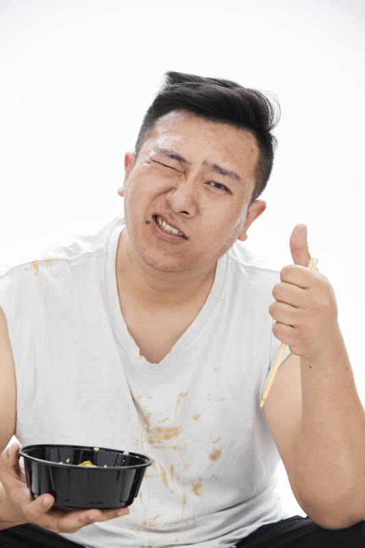 大吃特吃各种食物的肥胖亚洲男子