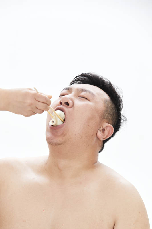 大吃特吃各种食物的肥胖亚洲男子