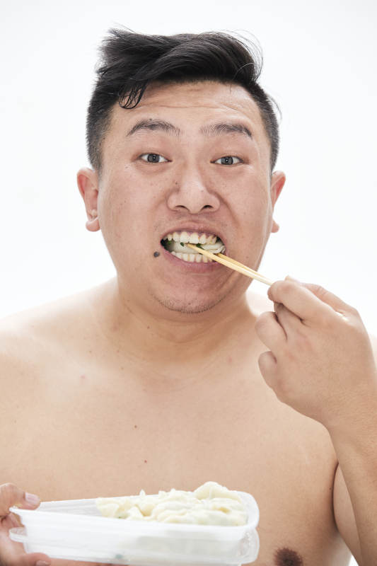 大吃特吃各种食物的肥胖亚洲男子