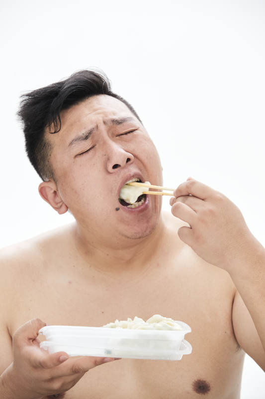 大吃特吃各种食物的肥胖亚洲男子