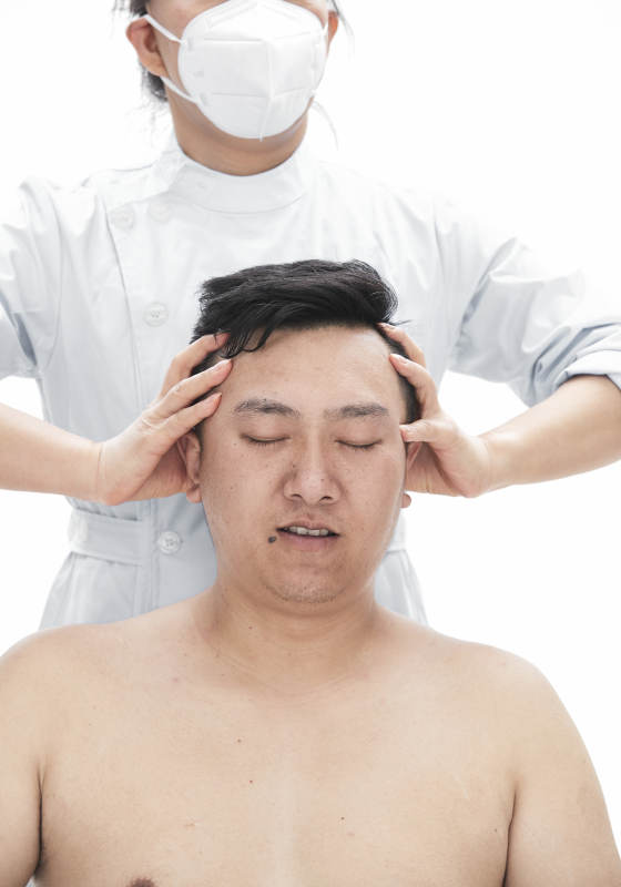 专业按摩师为男子进行身体按摩