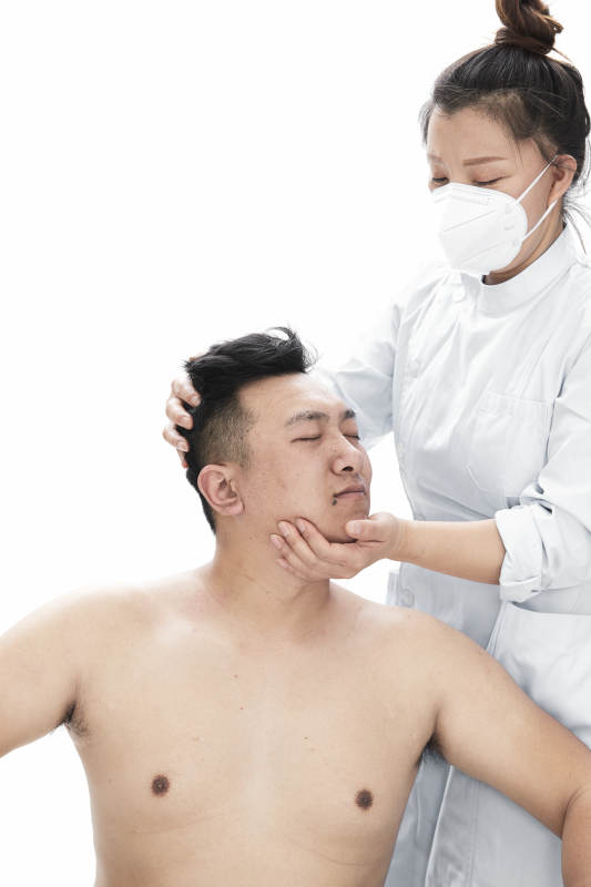 专业按摩师为男子进行身体按摩