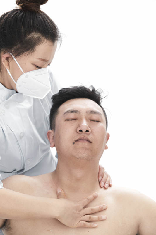 专业按摩师为男子进行身体按摩