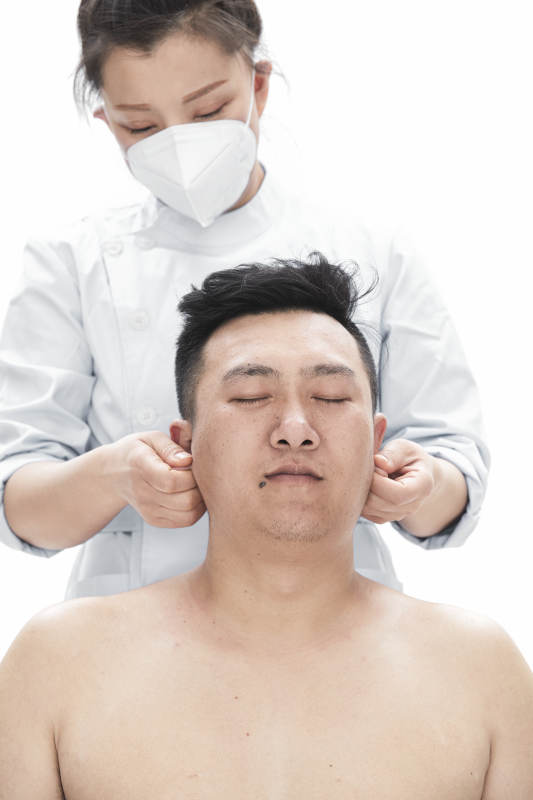 专业按摩师为男子进行身体按摩