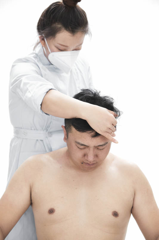 专业按摩师为男子进行身体按摩